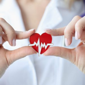 Doctor holds in his hands an icon with cardiogram of heart